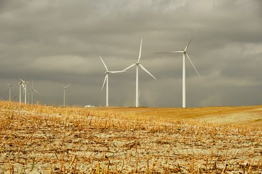 The wind turbines against the background of the cloudy sky.