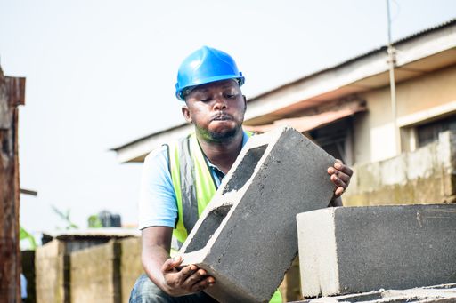 An African construction worker wearing the reflective jacket while working on a building site
