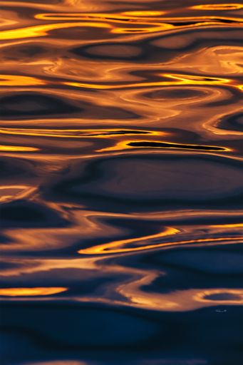 A vertical shot of water waves with long exposure during a beautiful sunset