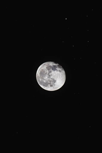 A detailed view of the moon against a dark night sky with scattered stars, showcasing its craters and surface features.
