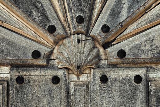 A closeup of wooden planks with a small seashell figure in the middle under the lights
