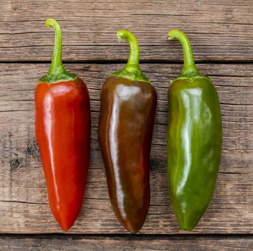 A high angle view of colorful peppers on a wooden table under the lights