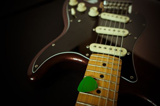 A closeup shot of an electric guitar on a black surface