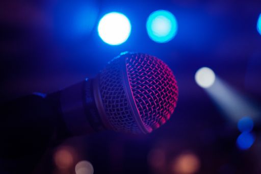 Close up of Shure SM58 microphone on a stand taken on Live performance stage under concert / gig lighting  during sound check.