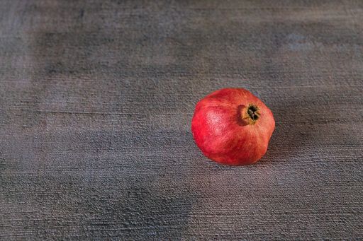 A top view of a pomegranate on a gray background
