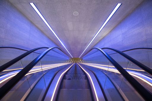 A high angle shot of an underground entrance with three escalators