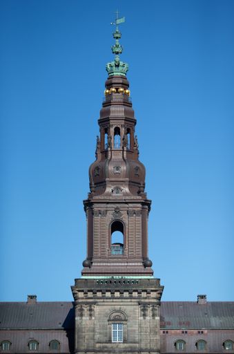 A low angle shot of the Christiansborg Palace tower on a clear sky background