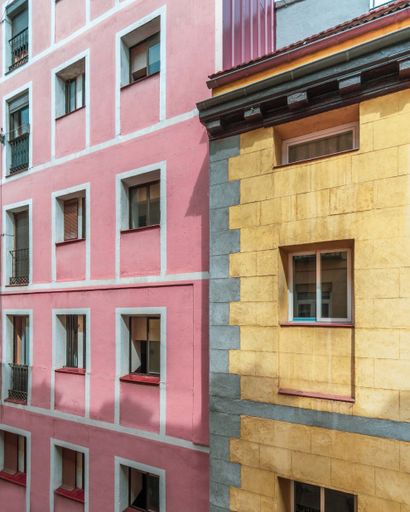 A vertical shot of a colourful European-style pink and yellow facade.