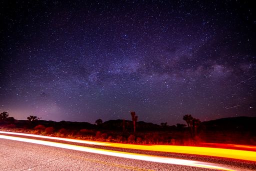 A beautiful shot of a road under the starry night sky