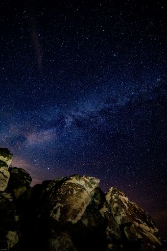 A beautiful shot of a rock under the starry night sky