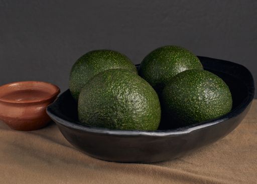 A closeup shot of fresh avocados on a black plate