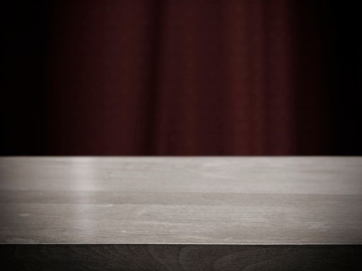 A wooden table with a blue curtain in the background / Can be used as product display.