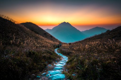 A narrow path with stones in the mountains during a beautiful sunset