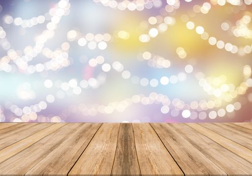 An empty wooden table with festive bokeh lights on colorful background for copy space