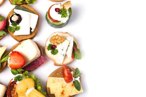 Different canapes with smoked salmon, cucumber, cherry tomatoes and mozzarella - copy space