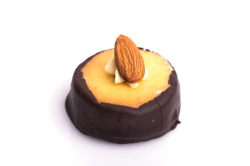 A closeup shot of a sweet canape topped with almond nut isolated on a white background