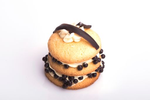 A closeup shot of a sweet canape topped with chocolate bits isolated on a white background