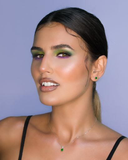 An attractive young Hispanic female with beautiful makeup against the blue background