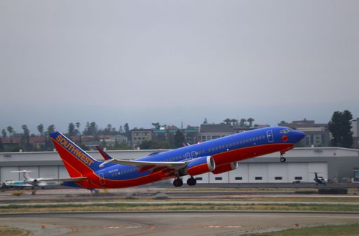 Southwest Airlines Boeing 737 MAX 8 taking off from San Jose airport with NetJets hangar in background