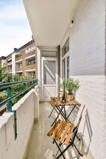 A vertical shot of a beautiful building balcony with wooden chairs and decorations