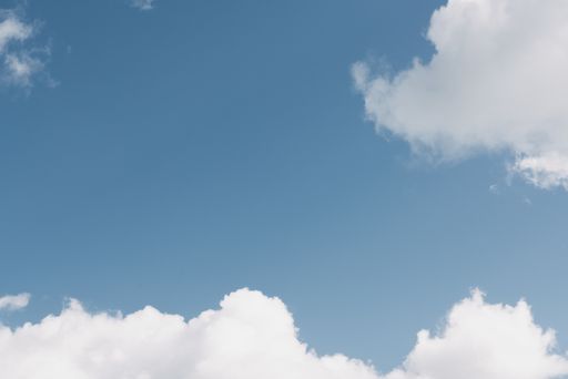 A wide shot of a clear blue sky with white clouds