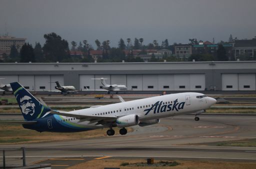Alaska Airlines Boeing 737-800 takes off from San Jose International Airport en route to Puerto Vallarta, with NetJets aircraft in the background.