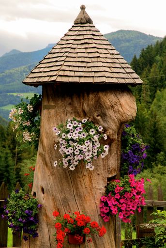 A vertical shot of a trunk decorated with flowers as a house.
