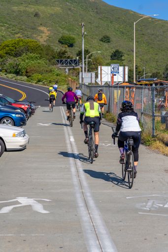 A back view of young bicyclists riding on the Golden Gate Bridge in San Francisco on a sunny day