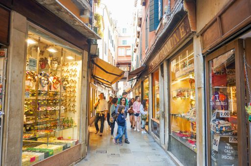 The people walking on a small street with shops and stores in the city center