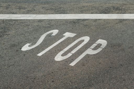 A high angle shot of a stop sign on the road as an obligatory traffic rule