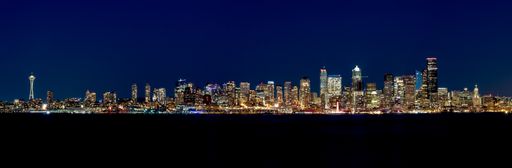 A panoramic view of Seattle surrounded by lights and the sea during the night in the US