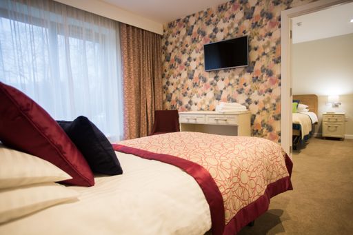 A shot of a stylish bedroom interior with a modern TV attached to a textured painted wall
