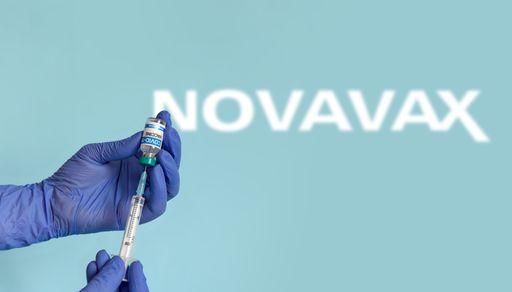 Hand holding coronavirus vaccine vial and syringe on blue background with novavax logo