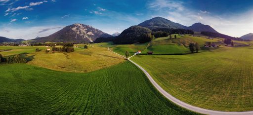 The aerial view of a green field under the sky