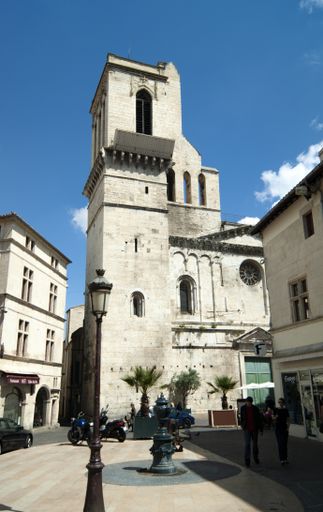 The old famous Nimes Cathedral in Romanesque and Gothic style against a blue sky on a sunny day