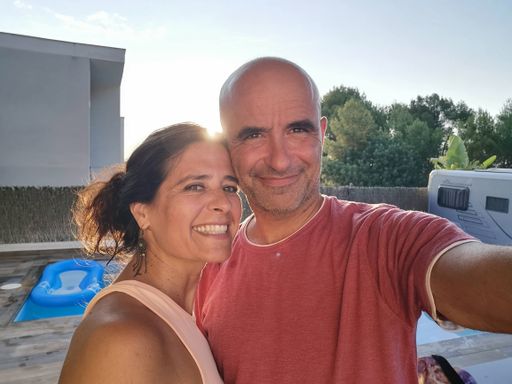 An adult attractive middle-aged Hispanic happy smiling couple taking a selfie outdoors on a sunny day