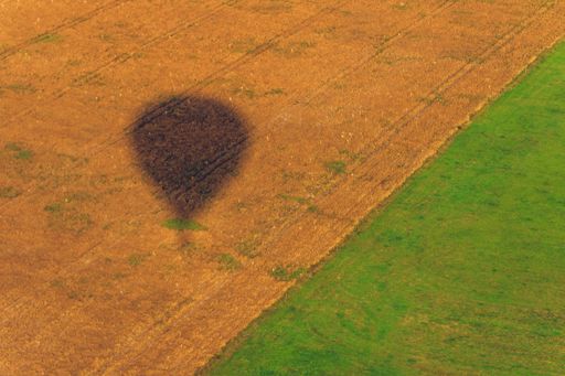 An aerial view of the shadow of an air balloon in the fields in the Klaipeda region, Lithuania