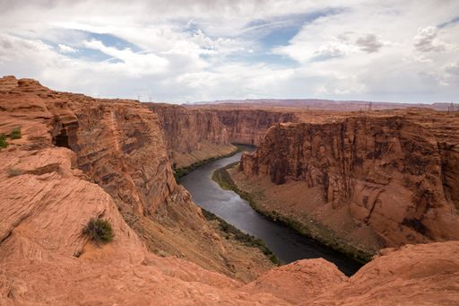 The Colorado river flowing through the Grand Canyon under a blue cloudy sky on a sunny day