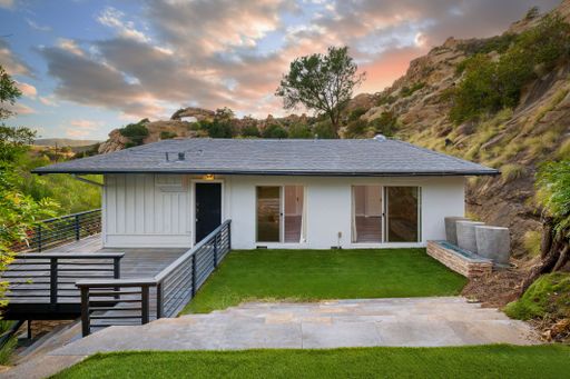 Modern luxury home featuring oversized windows, designer decor, spacious bedrooms, and sweeping views of the surrounding hills.