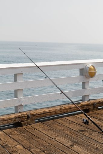 A vertical shot of a fishing pole in Malibu Pier