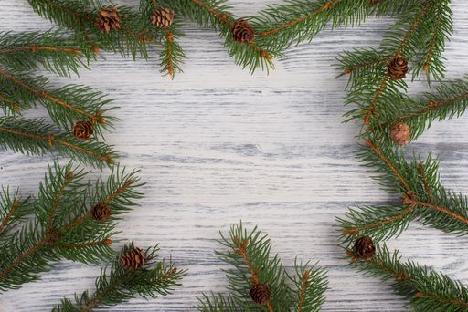 Christmas backdrop with branches of fir, empty copy space in the middle, wooden background