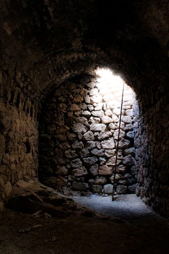 A vertical shot of the inside of a tunnel and sunlight coming from a hole