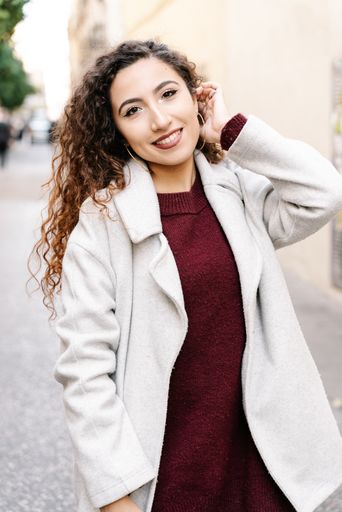 A vertical shot of a beautiful female fixing her hair while looking at the camera