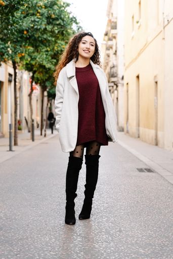 A vertical shot of an attractive female standing while looking at the camera