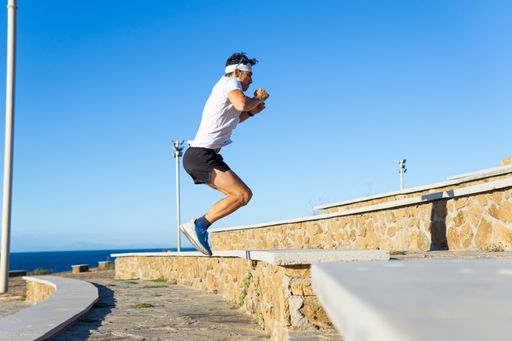 Young caucasian man exercising in the park jumping a step, healthy lifestyle