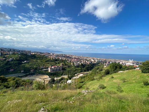 Beautiful view over the City of Trabzon, Turkey overlooking the Black Sea merged with the skyline. Nicely shaped white clouds in the clear blue sky.