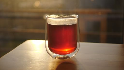 Black ceylon Tea in glass cup at sunset