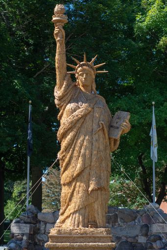A vertical shot of The Statue of Liberty made from straw at a small town