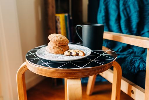 A plate of delicious cookies next to a black mug of coffee on a black table in a coffee house