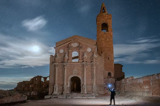 The shattered San Martin de Tours church against starry sky late in the evening in Belchite, Spain